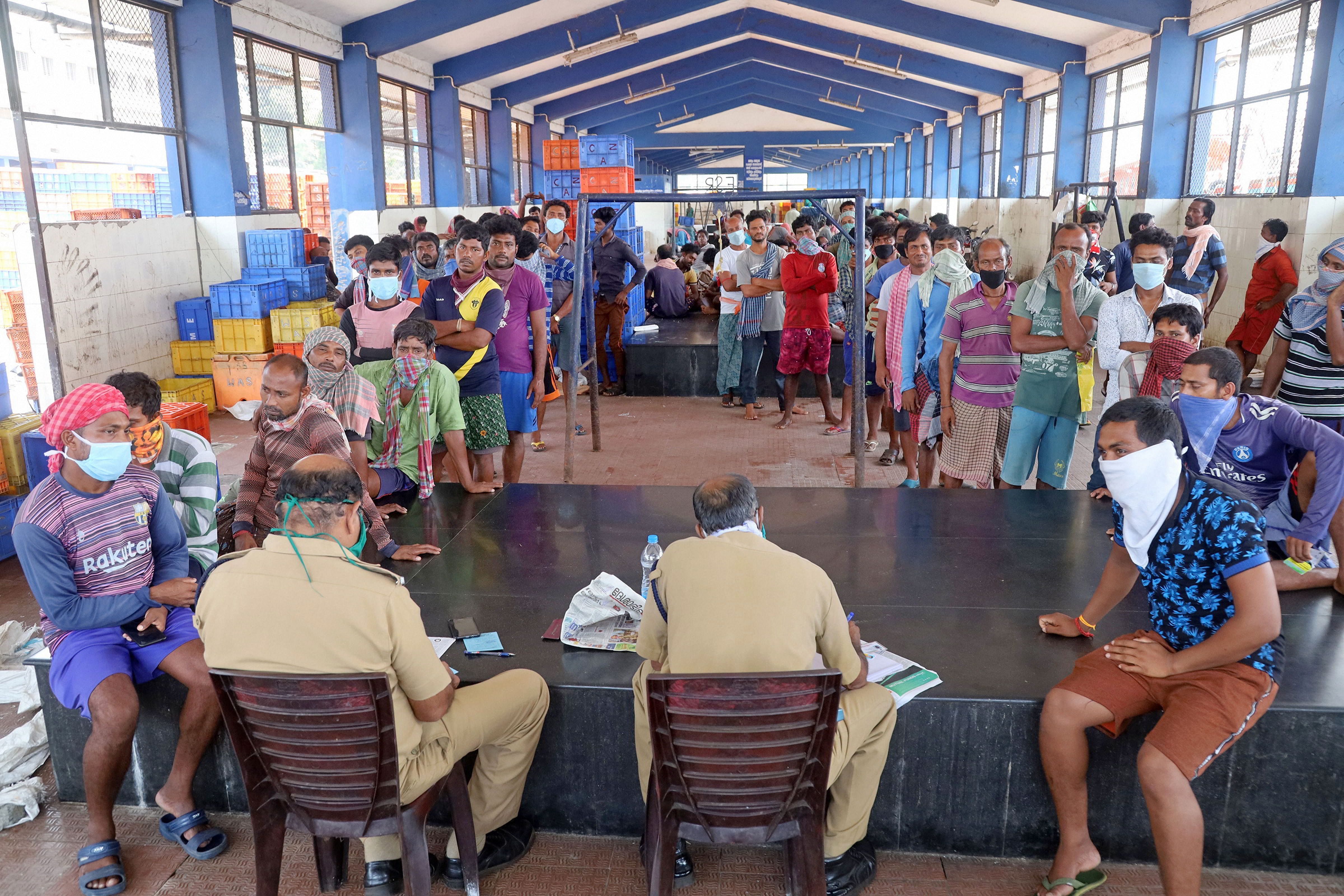 Police distribute ID cards to stranded migrant labours during the nationwide lockdown, imposed in wake of the coronavirus outbreak. (PTI Photo)