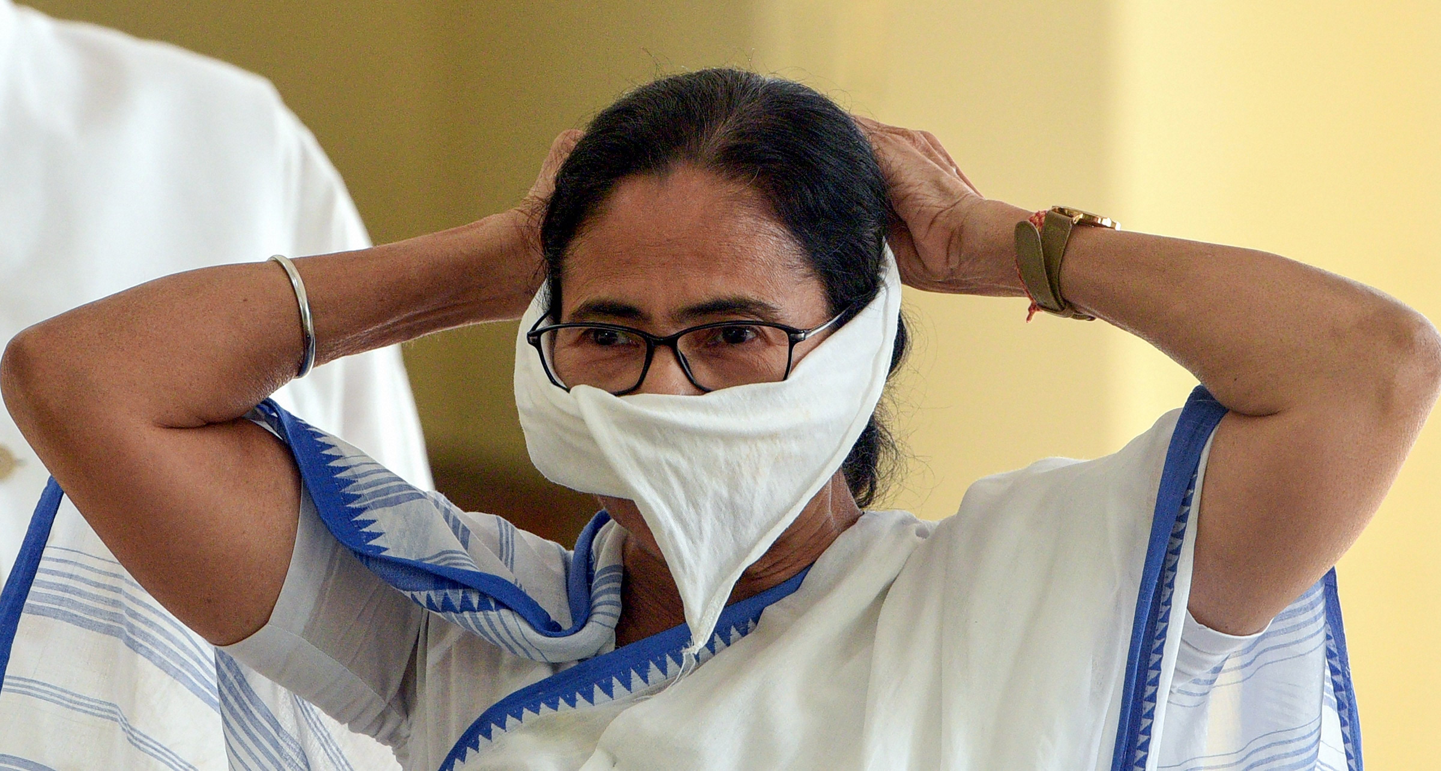 West Bengal Chief Minister Mamata Banerjee covers her mouth with a piece of cloth during a press conference on coronavirus. (PTI Photo)