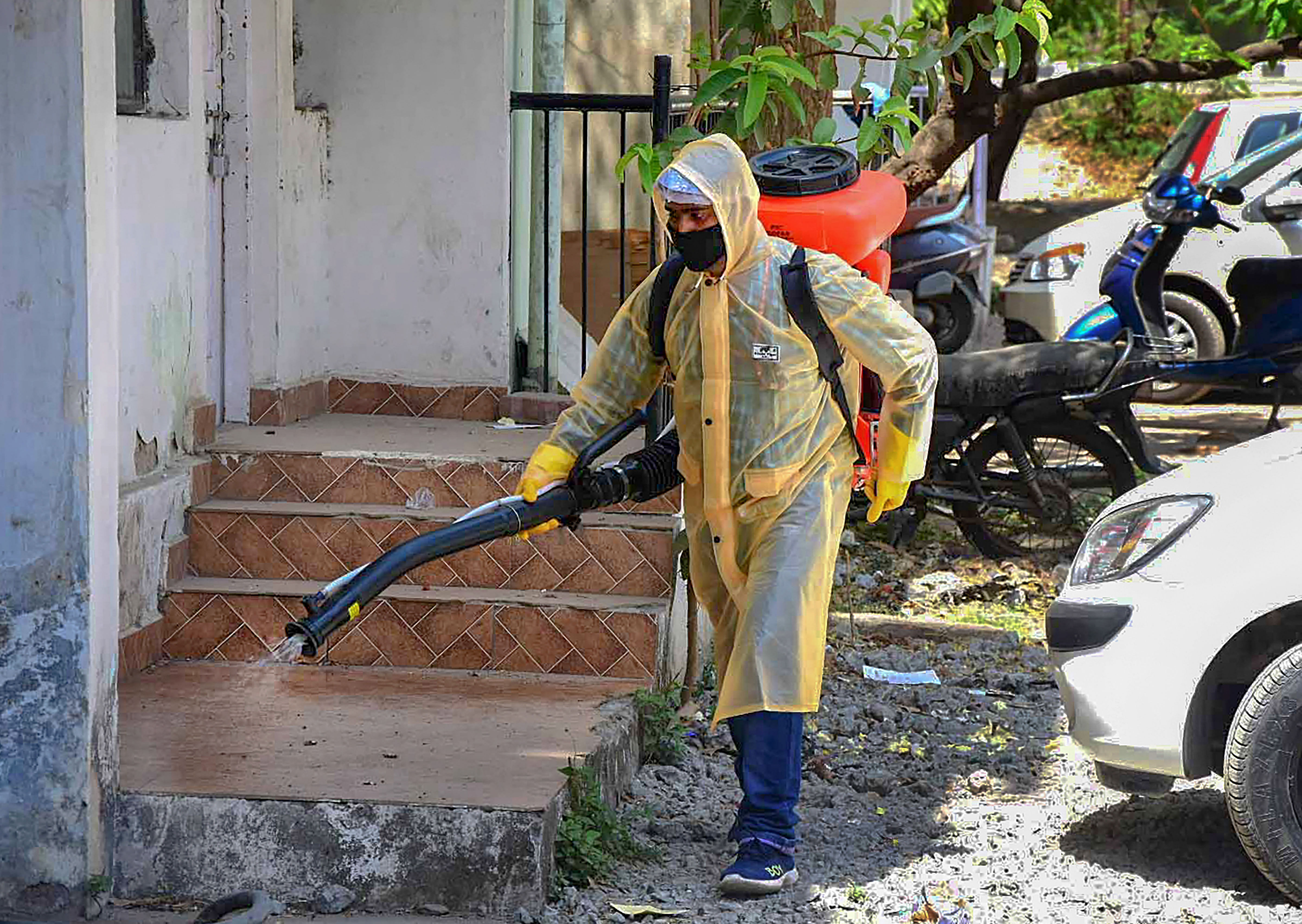 A BMC worker sprays disinfectant in the premises of a residential area to contain the spread of coronavirus during lockdown, in Bhopal. (Credit: PTI)