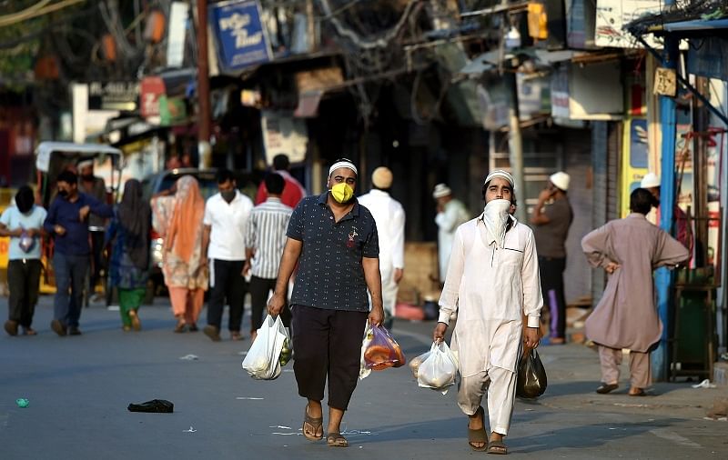 Members of the Muslim community carry essential items for iftar on the first day of holy month of Ramzan during a nationwide lockdown in the wake of coronavirus pandemic, at Jama Masjid. (PTI Photo)