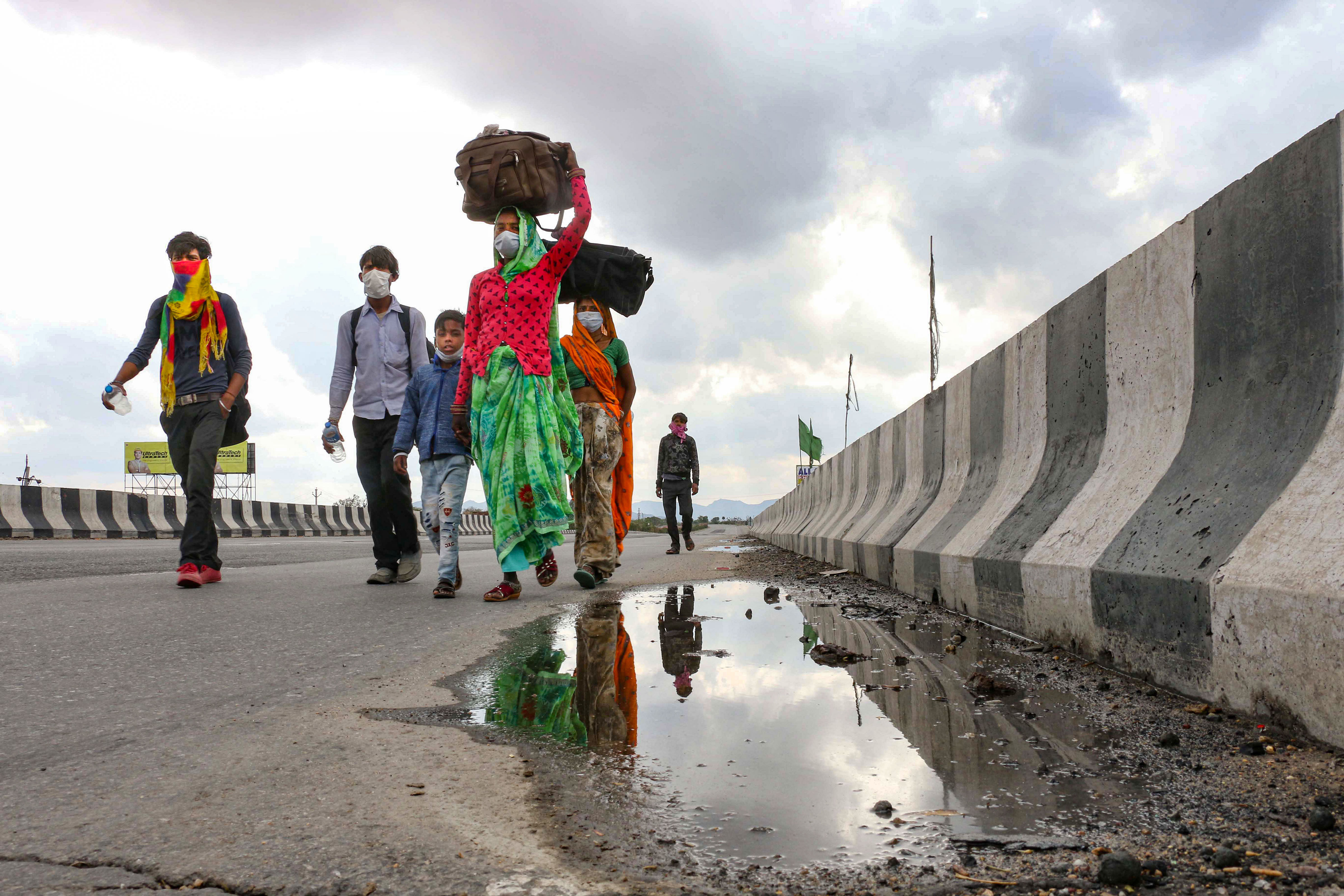 Migrant workers along with their familes walk to return to their villages after government imposed a 21-day nationwide lockdown, in wake of coronavirus pandemic, in Bengaluru. (PTI Photo)