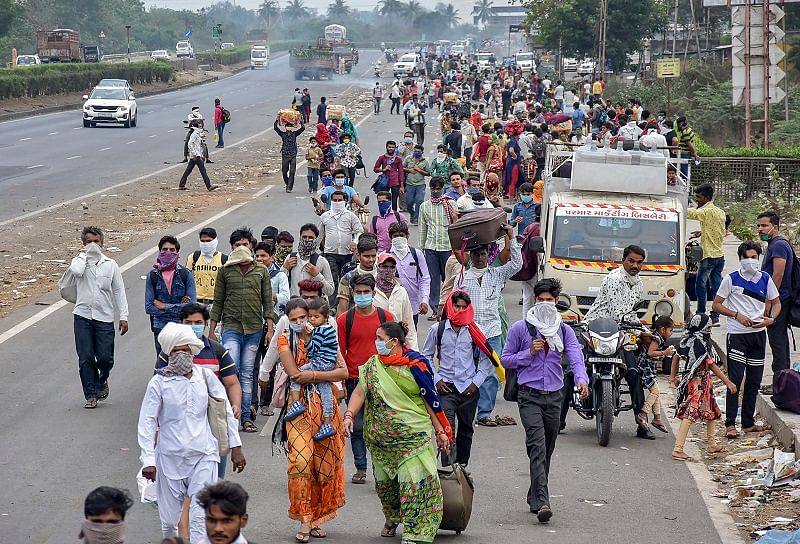 Migrant workers and their families walk on a road to return to their villages after the government imposed a 21-day nationwide lockdown to limit the spread of coronavirus, in Surat. (PTI Photo)