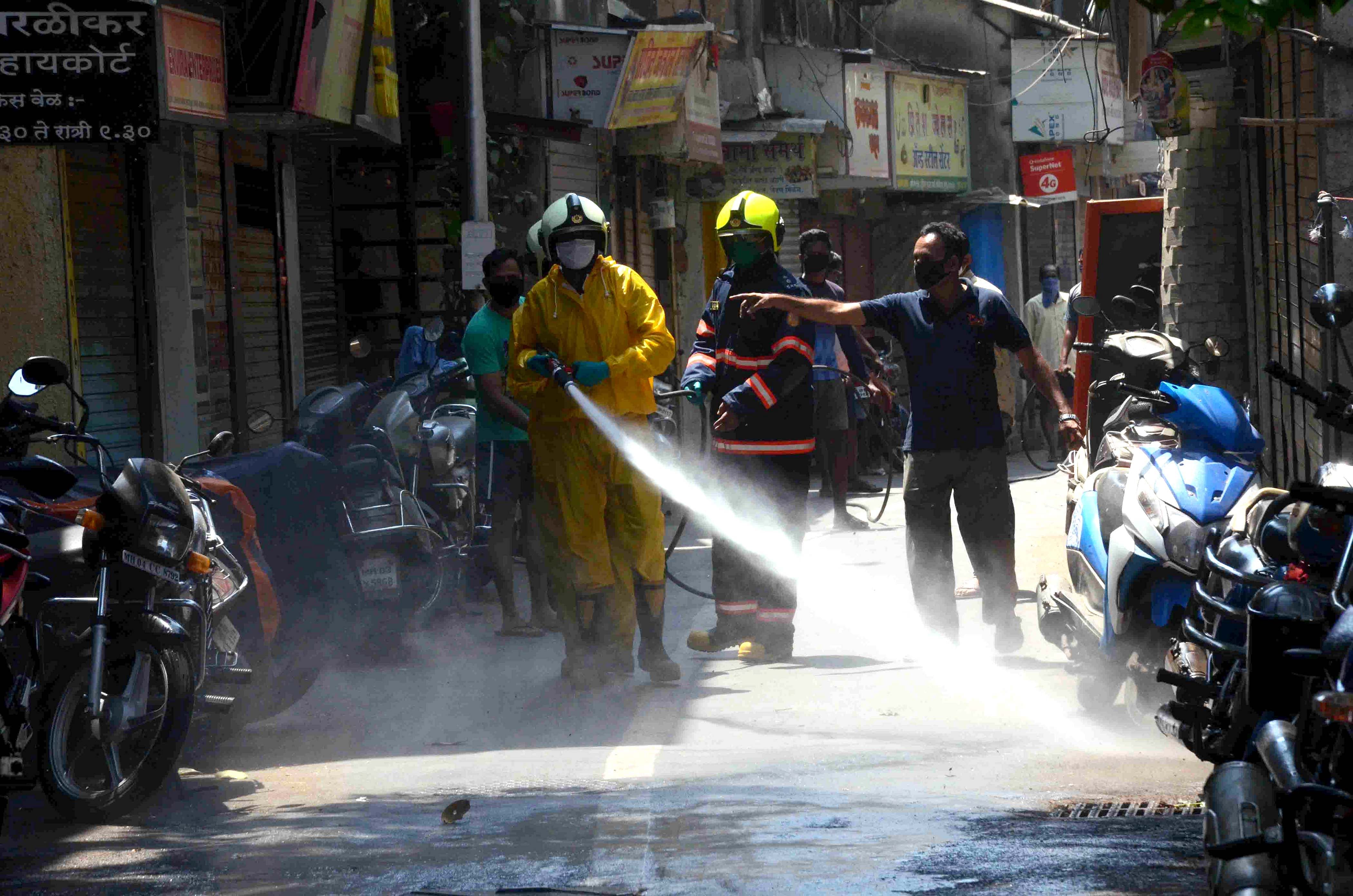A BMC worker sprays disinfectant at a market to contain the coronavirus during a nationwide lockdown. (Credit: PTI)
