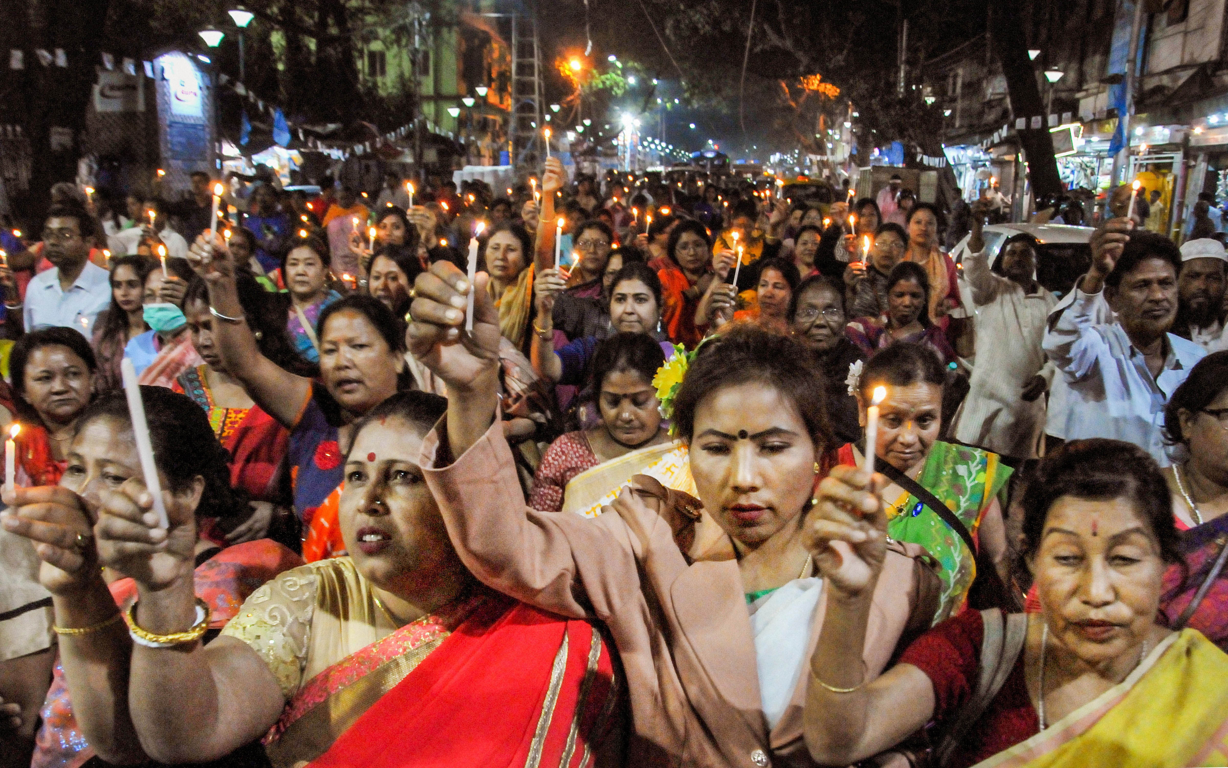 Hawkers participate in a candle march during a protest against the Delhi violence. (PTI Photo)