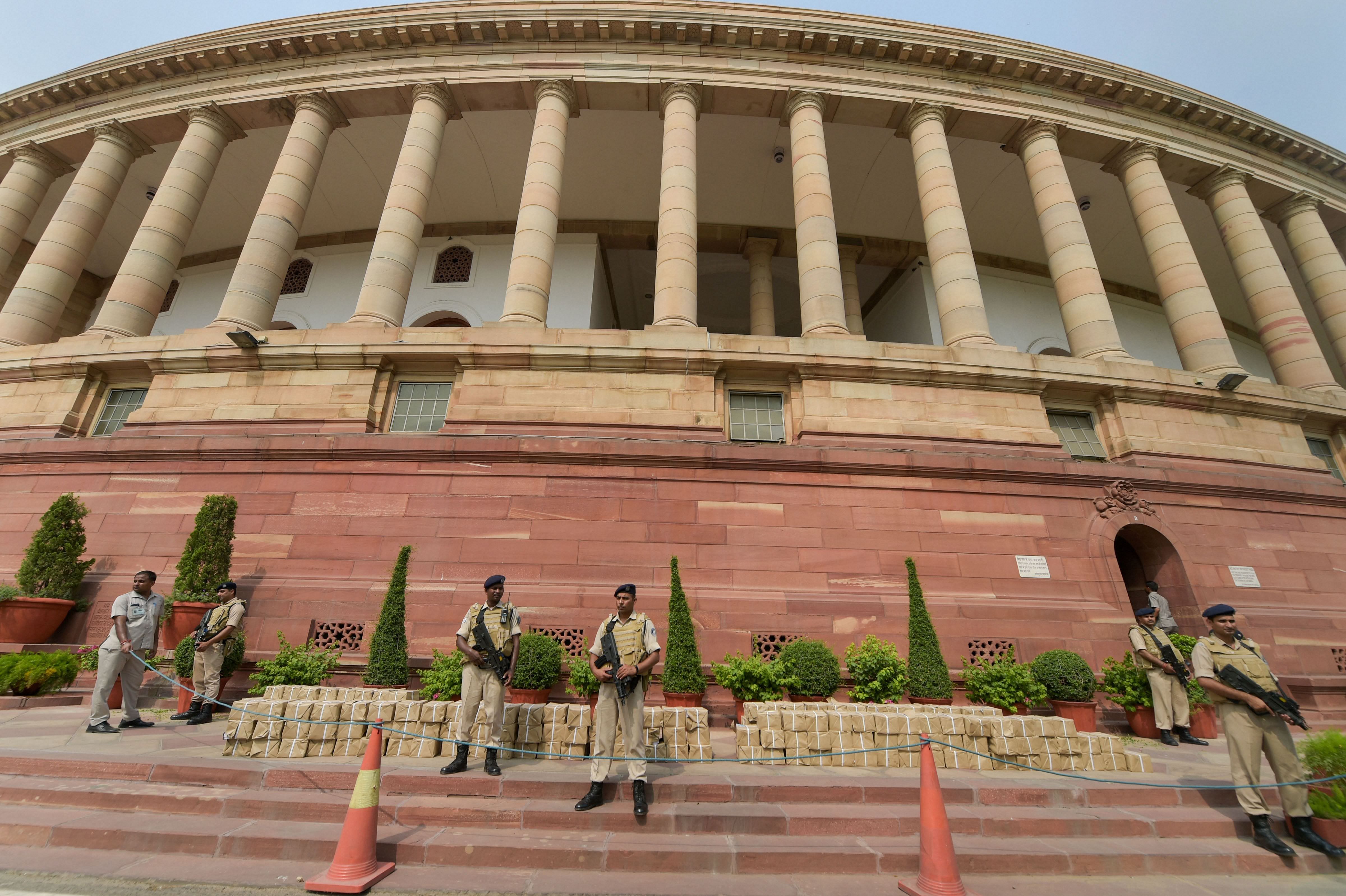 Security personnel stand guard in front of the bundles containing the copies of Economic Survey 2018-19, at Parliament, in New Delhi. (PTI Photo)