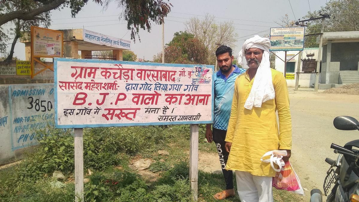 Gautam Buddh Nagar: People install a signboard against BJP in the Union minister Mahesh Sharma's adopted village Kachera in Gautam Buddh Nagar district, Tuesday, April 02, 2019. (PTI Photo)