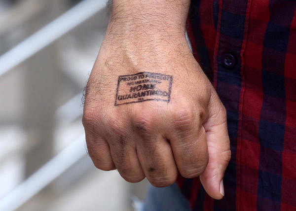 A man shows his hand which was stamped by a doctor advising for home quarantine after a swab was taken from him to test for coronavirus disease (COVID-19), at a residential area in Mumbai. (Credit: Reuters Photo)