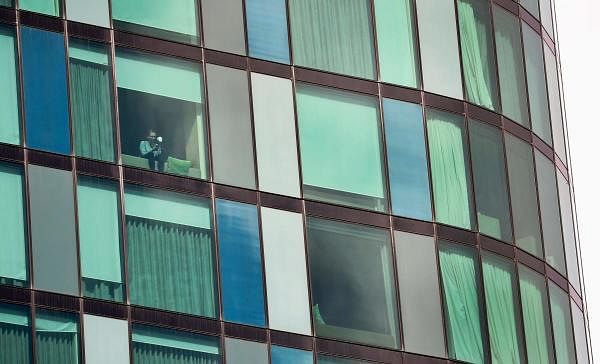 A woman looks out of the window in an inner-city hotel where travellers returned from overseas are staying in isolation in Melbourne on March 30, 2020. (Credit: AFP Photo)