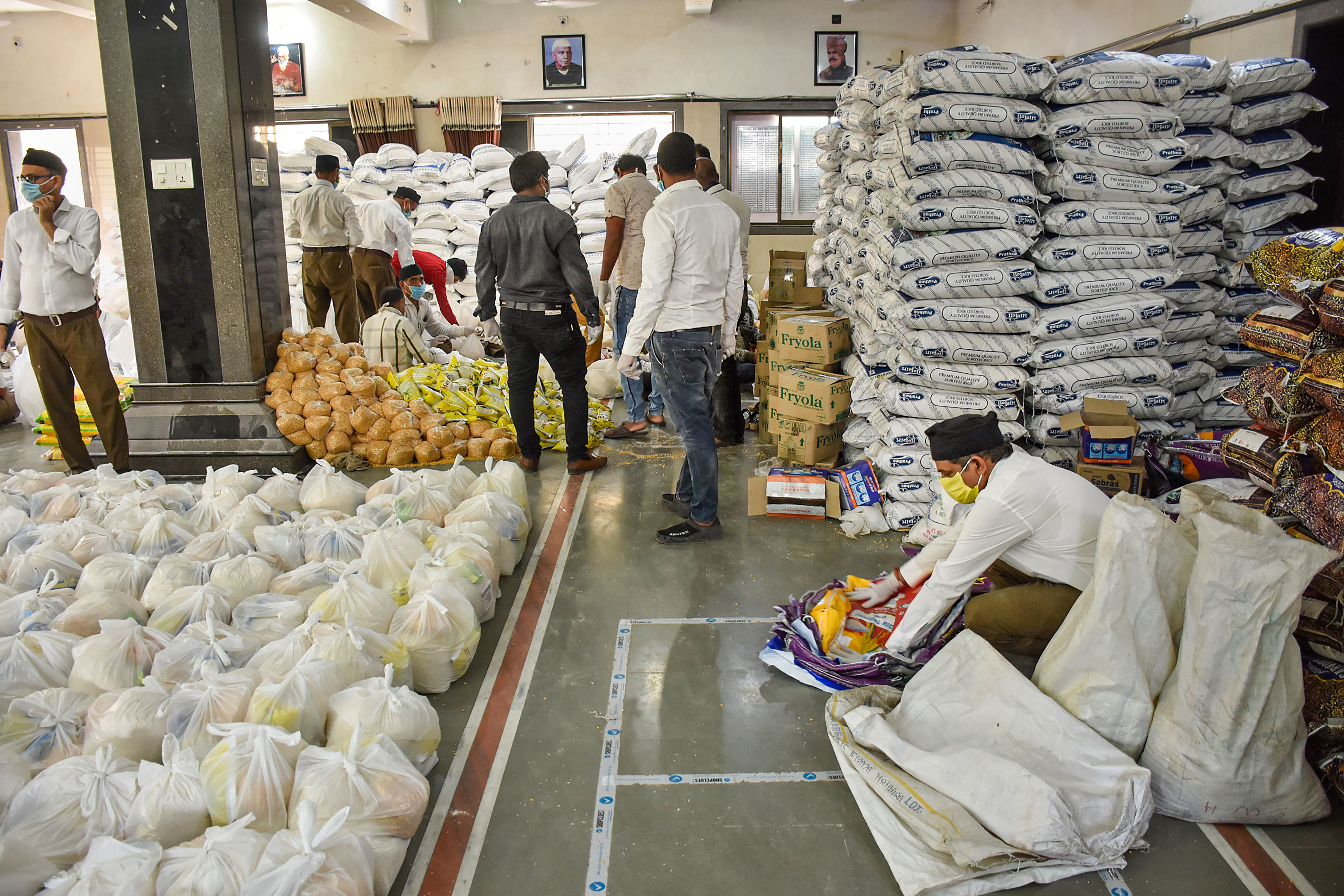 RSS workers pack food to distribute among needy people during a nationwide lockdown in the wake of coronavirus pandemic. (Credit: PTI Photo)