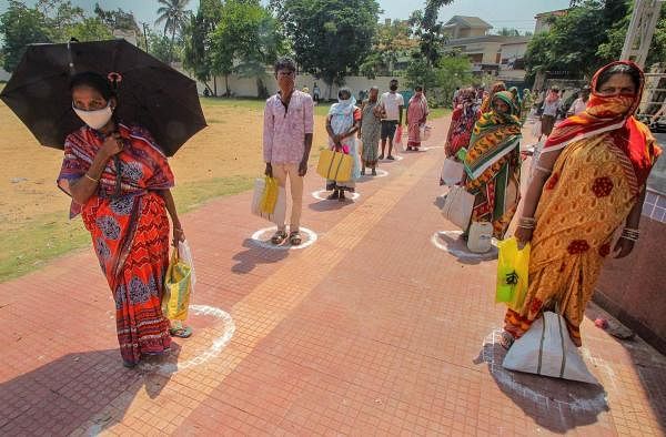 Beneficiaries stand in a queue, maintaining social distancing, to collect ration at state government PDS ration centre during the nationwide lockdown amid coronavirus outbreak, in Bhubaneswar. (PTI Photo) 