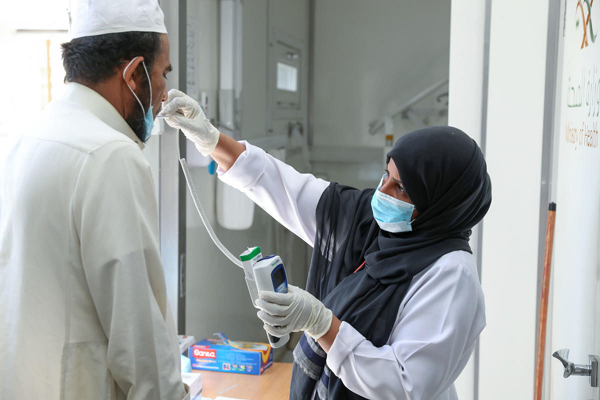 A Saudi nurse checks a patient's temperature at a mobile clinic catering for the residents of Ajyad Almasafi district in the holy city of Mecca. Credit: AFP Photo