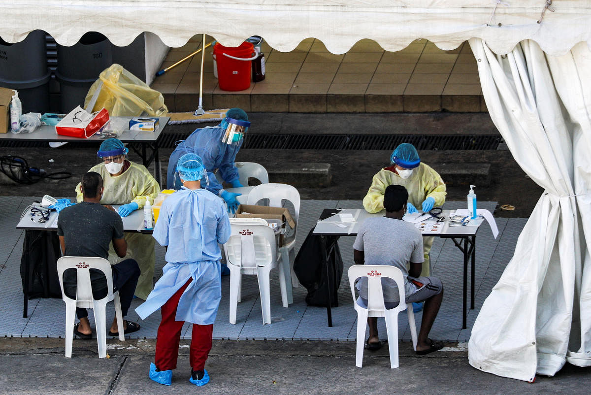 Medical personnel attend to migrant workers at a dormitory amid the coronavirus disease (Reuters Photo)