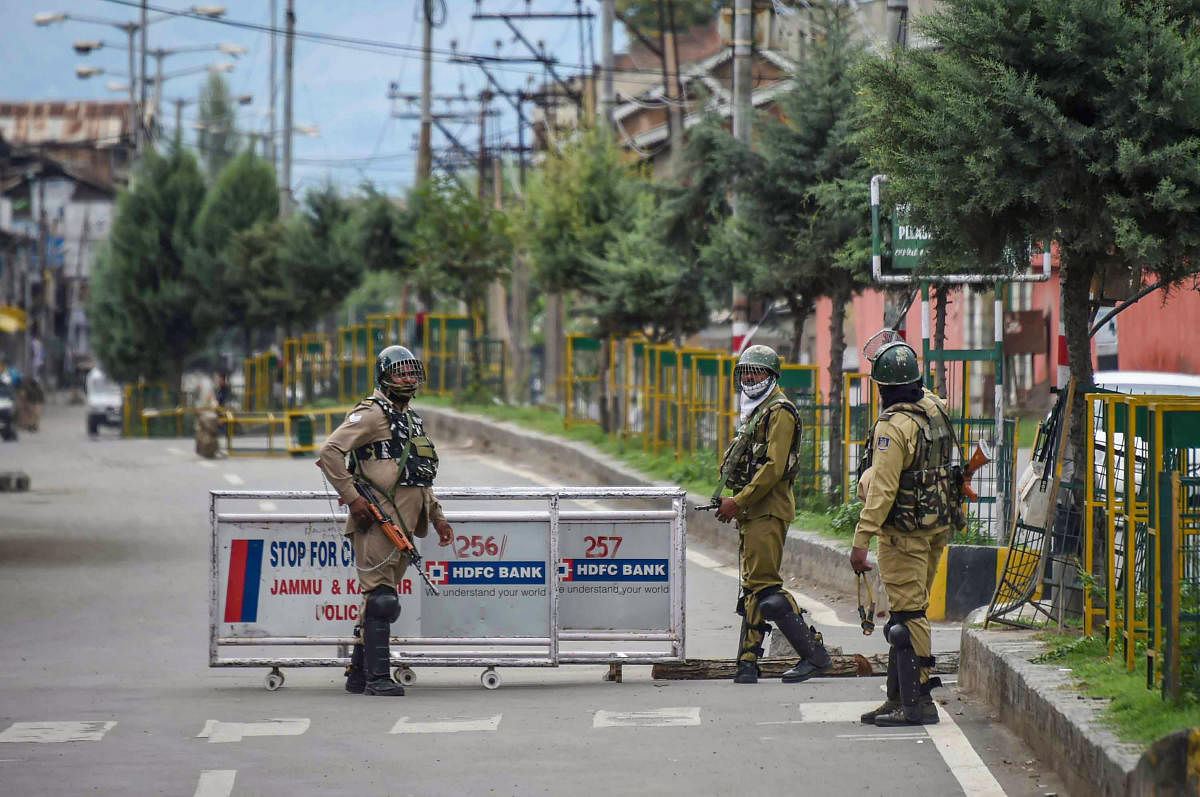 Security personnel stand guard at a check-point, during curfew like restrictions on the 13th consecutive day, following the abrogation of the provisions Article 370 in Jammu and Kashmir, in Srinagar, Saturday, Aug. 17, 2019. (PTI Photo)