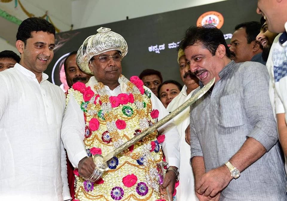 Karnataka Chief Minister Siddaramaiah shares a light moment as he touches the sword to the neck of MLA Zameer Ahmad during Tipu Jayanti celebrations at Vidhan Soudha in Bengaluru on November 10, 2017.