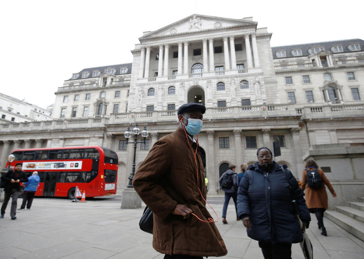 A man, wearing a protective face mask, walks in front of the Bank of England, following an outbreak of the coronavirus, in London. Credit: Reuters File Photo