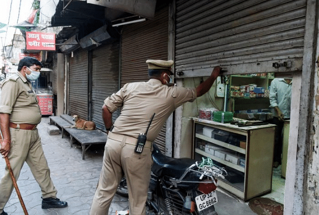 Police personnel urge a shopkeeper to close his shop during a nationwide lockdown in the wake of coronavirus pandemic, in Lucknow. (PTI Photo)