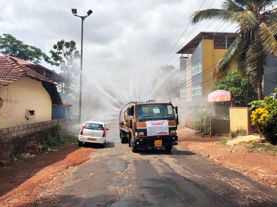 Disinfectant being sprayed in Shakthinagara, Mangaluru, on Tuesday after a mother and son tested positive. Credit: DH Photo