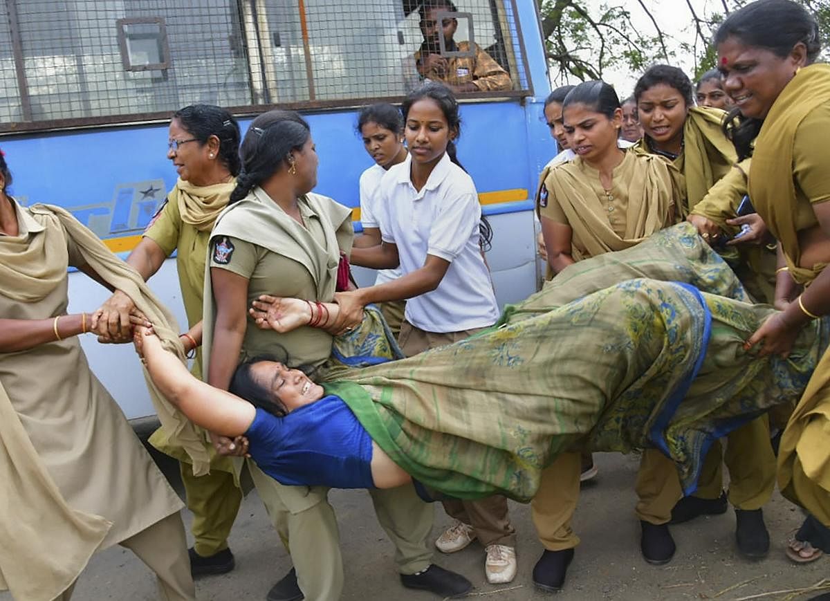 Police personnel detain a protestor during a farmers demonstration in Amaravati. (Credit: PTI photo)