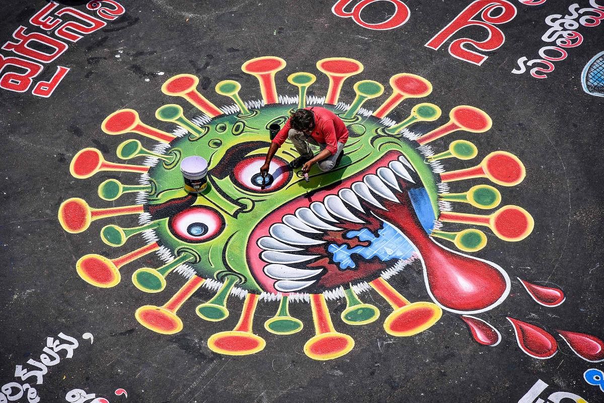 An artist paints a graffiti on a road depicting the coronavirus as an attempt to raise awareness about the importance of staying at home. PTI