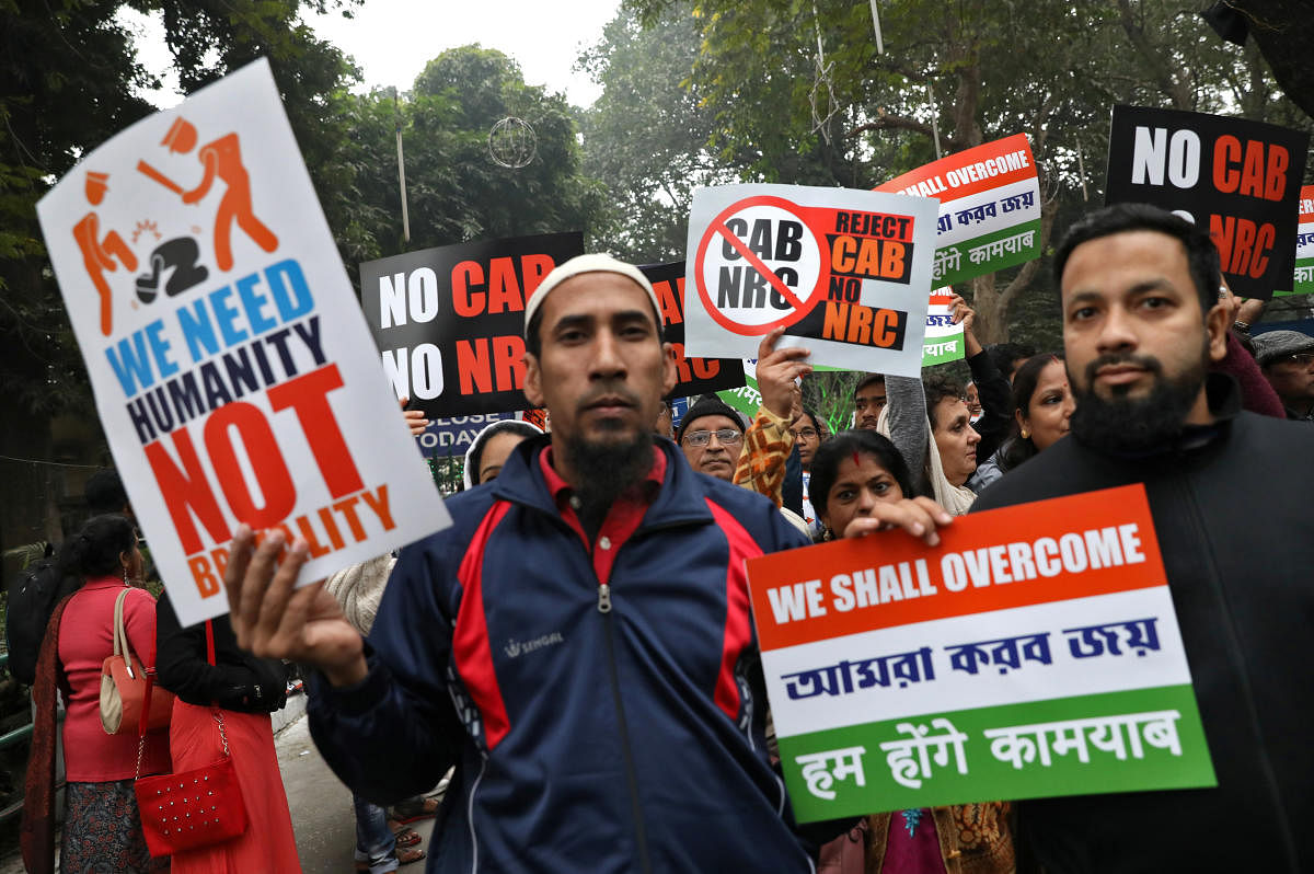 Demonstrators display placards during a silent rally to protest against a new citizenship law, in Kolkata. Reuters