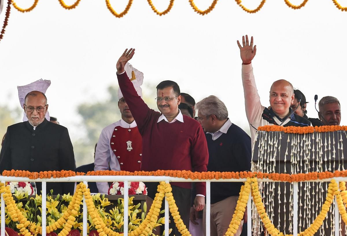 Delhi Chief Minister Arvind Kejriwal and newly sworn-in minister Manish Sisodia wave at crowd after their oath ceremony at Ramlila Maidan in New Delhi, Sunday, Feb. 16, 2020. Delhi Lt. Governor Anil Baijal is also seen. PTI