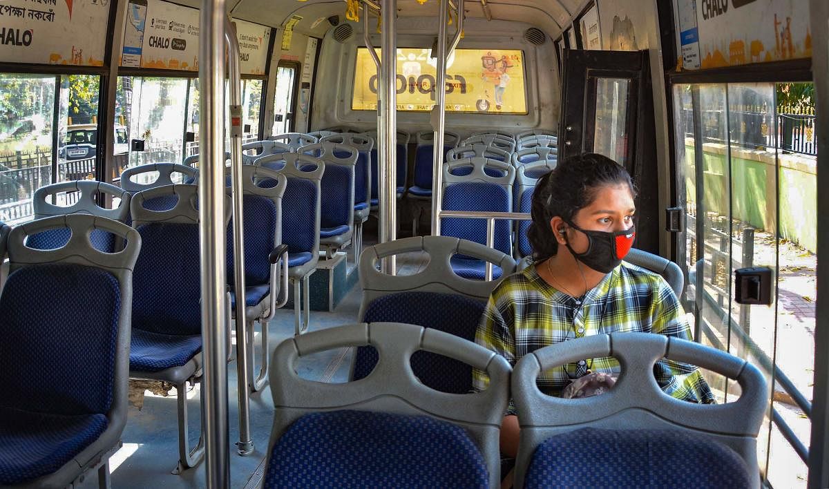 A passenger wears a protective mask to mitigate the coronavirus pandemic as she sits inside an empty bus, in Guwahati, Thursday, March 19, 2020. (PTI Photo)