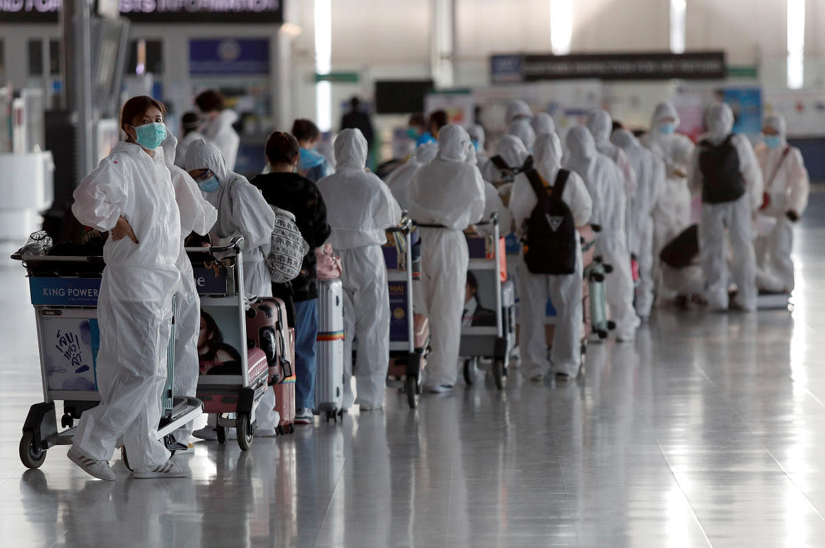Chinese students living in Thailand wear protective suits as a measure of protection against the coronavirus disease (COVID-19) as they queue at the Suvarnabhumi Airport before boarding a repatriation flight, in Bangkok, Thailand April 21, 2020. Credit: Reuters Photo