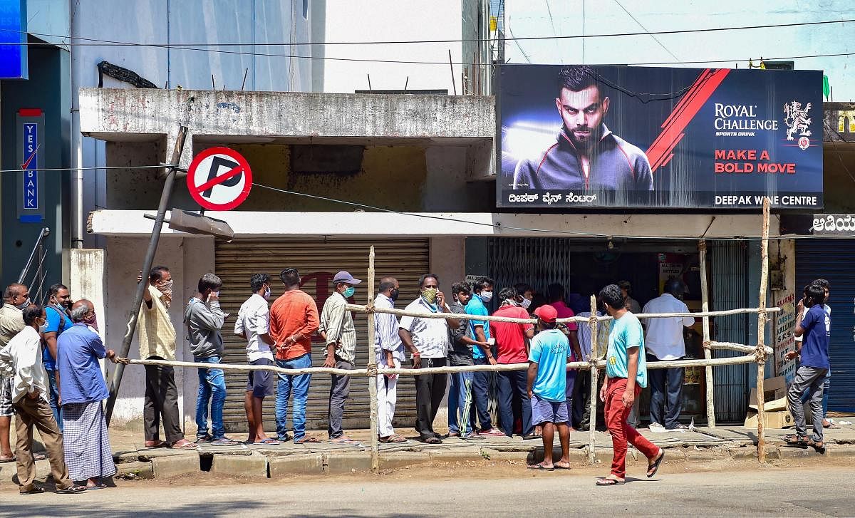 People stand in queue outside a liquor shop amid COVID-19 lockdown in Bengaluru, Monday, May 4, 2020. (PTI)