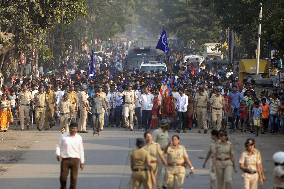 Policemen accompany the Dalits protestors as they stage a protest against the violence in Bhima Koregaon area of Pune, in Mumbai on Tuesday. Photo/PTI