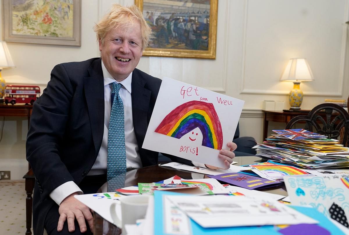 Boris Johnson is seen displaying his Get Well Soon cards sent in by children while he was ill with the novel coronavirus COVID-19 (AFP Photo)