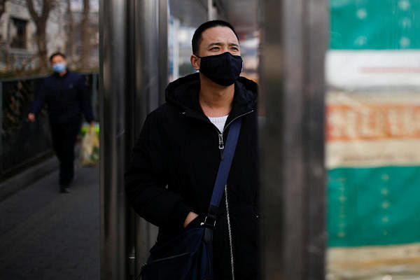 A man wearing a face mask looks at a board at a bus stop, as the country is hit by an outbreak of the new coronavirus, in Beijing, China January 27, 2020. (Reuters Photo)