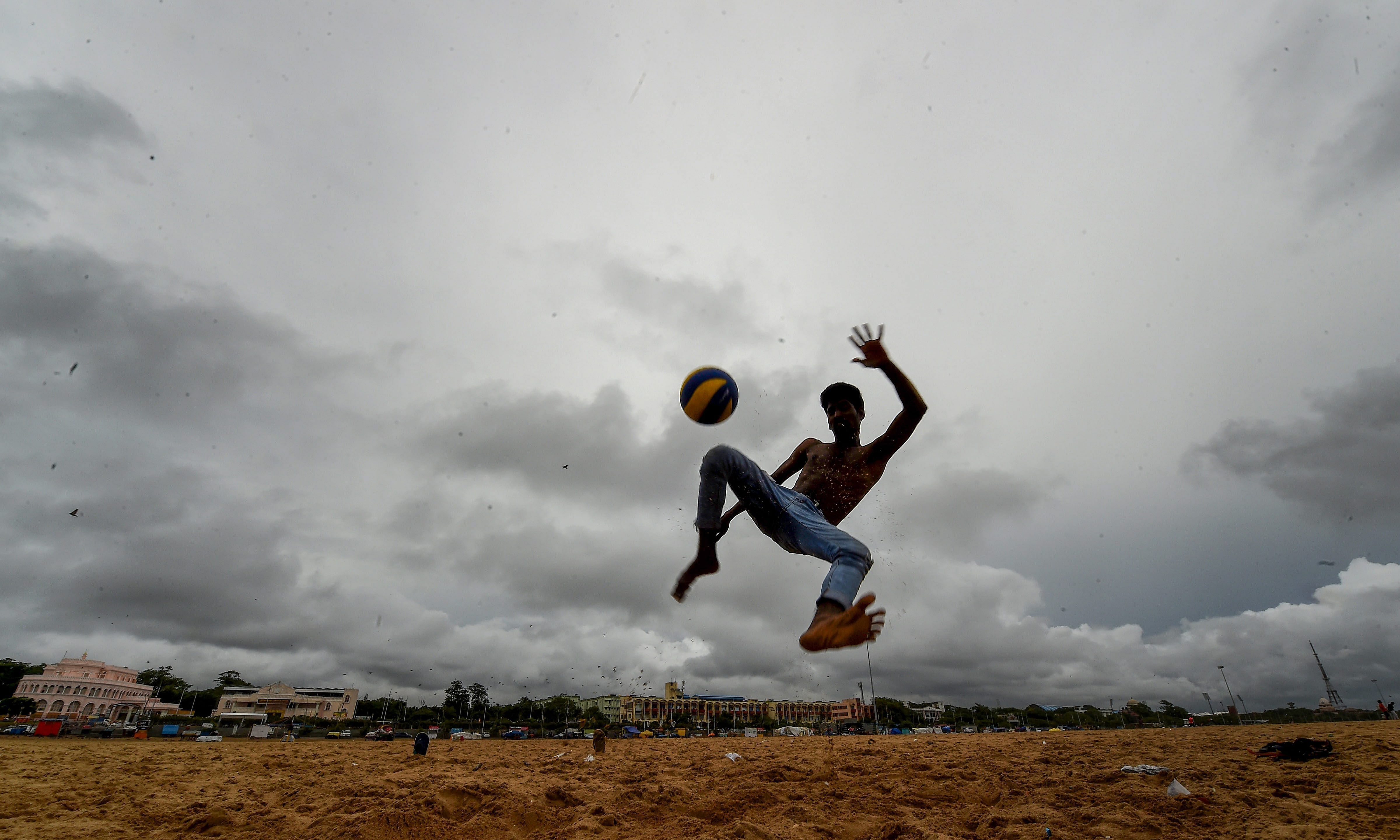 A boy plays football on a cloudy day at Marina beach in Chennai, on Friday. The Indian Meteorological Department has issued a warning predicting heavy to very heavy rainfall in the region with a red alert announced for three districts of Kerala – Idukki, Palakkad and Thrissur for October 7. PTI