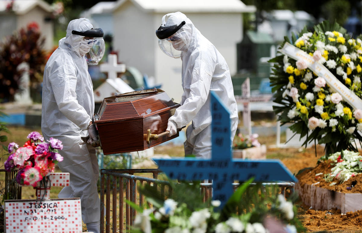 Gravediggers wearing protective suits carry the coffin of 68-years-old Natalina Cardoso Bandeira, who passed away due to coronavirus disease (COVID-19), at the Parque Taruma cemetery in Manaus, Brazil, April 10, 2020. Credit: Reuters Photo