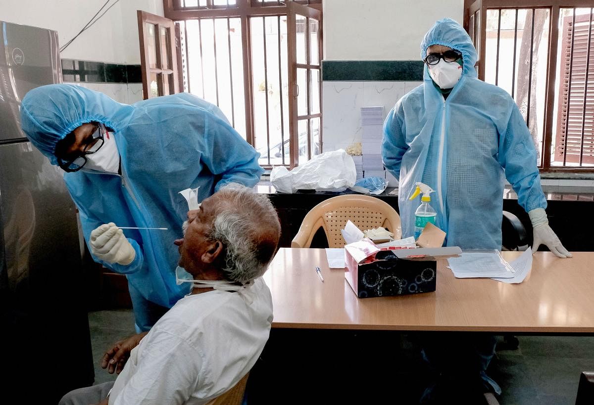 Medics collect swab from a person for COVID-19 test as part of a drive to control the spread of the new coronavirus in Mumbai (PTI Photo)