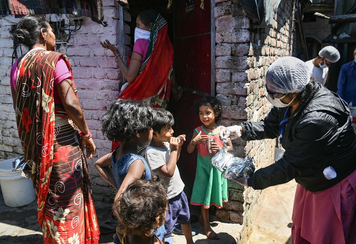 Members of an NGO give away food items to children at a slum, during ongoing COVID-19 lockdown in Dehradun, Tuesday, April 21, 2020. (PTI Photo) 