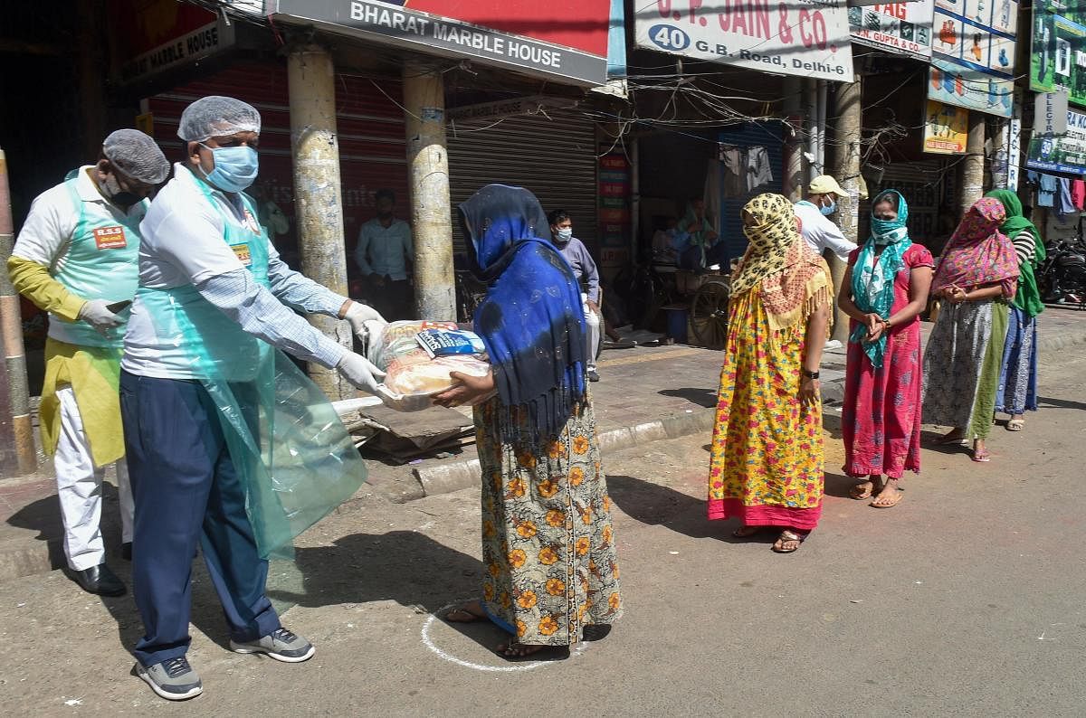 RSS workers distribute ration among sex workers at GB Road during a nationwide lockdown amid the coronavirus outbreak, in New Delhi, Friday, April 3, 2020. (PTI Photo)