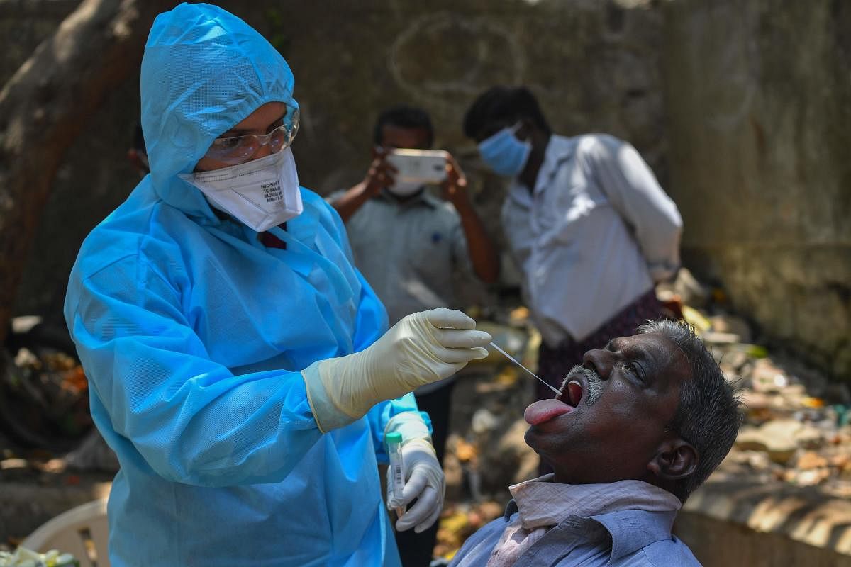 A doctor takes a swab sample during a COVID-19 coronavirus testing drive inside the Dharavi slums during a government-imposed nationwide lockdown as a preventive measure against the spread of the COVID-19 coronavirus, in Mumbai on April 16, 2020. Credit: AFP Photo