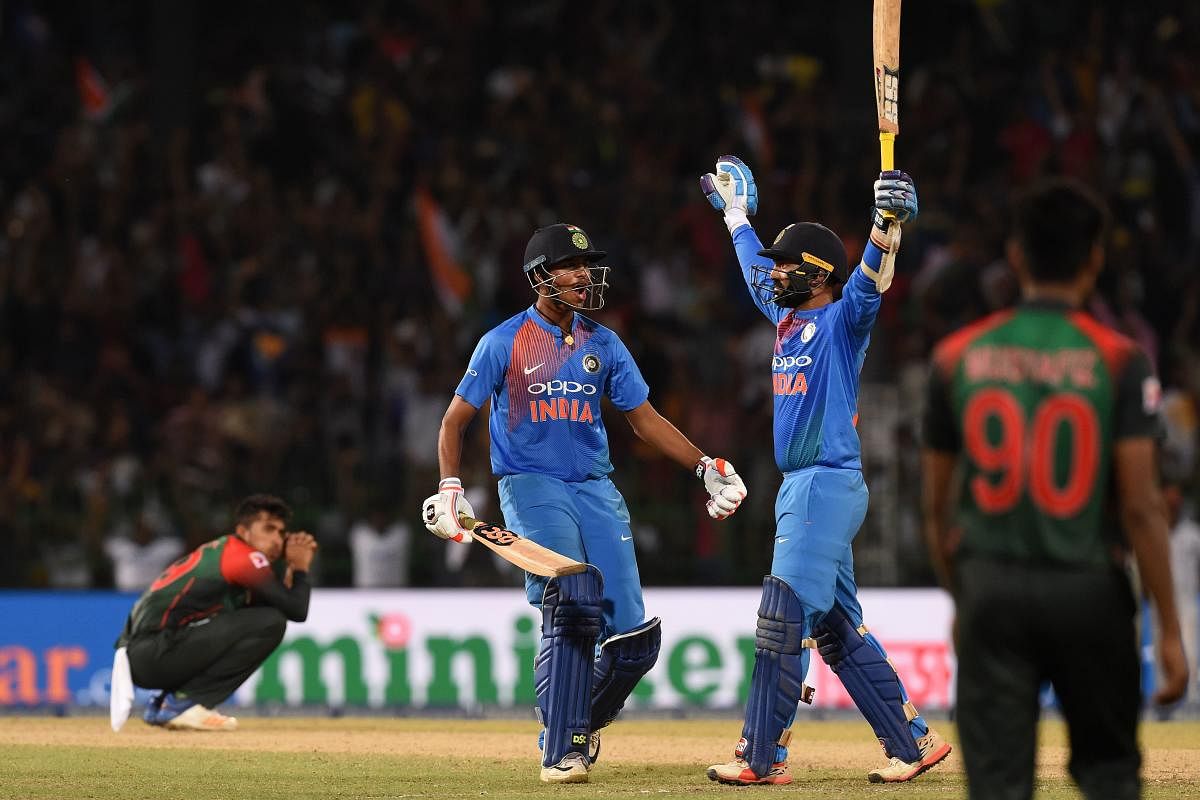 File photo of Dinesh Karthik and Washington Sundar after scoring the winning run to defeat Bangladesh by 4 wickets during the final of Nidahas Twenty20 Tri-Series. Photo credit: AFP
