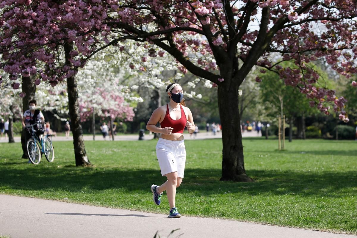 A jogger wears a facemask as she takes her daily excercise in Victoria Park, east London on April 11, 2020 as warm weather tests the nationwide lockdown due to the novel coronavirus COVID-19 and the long Easter weekend begins. Credit: AFP Photo
