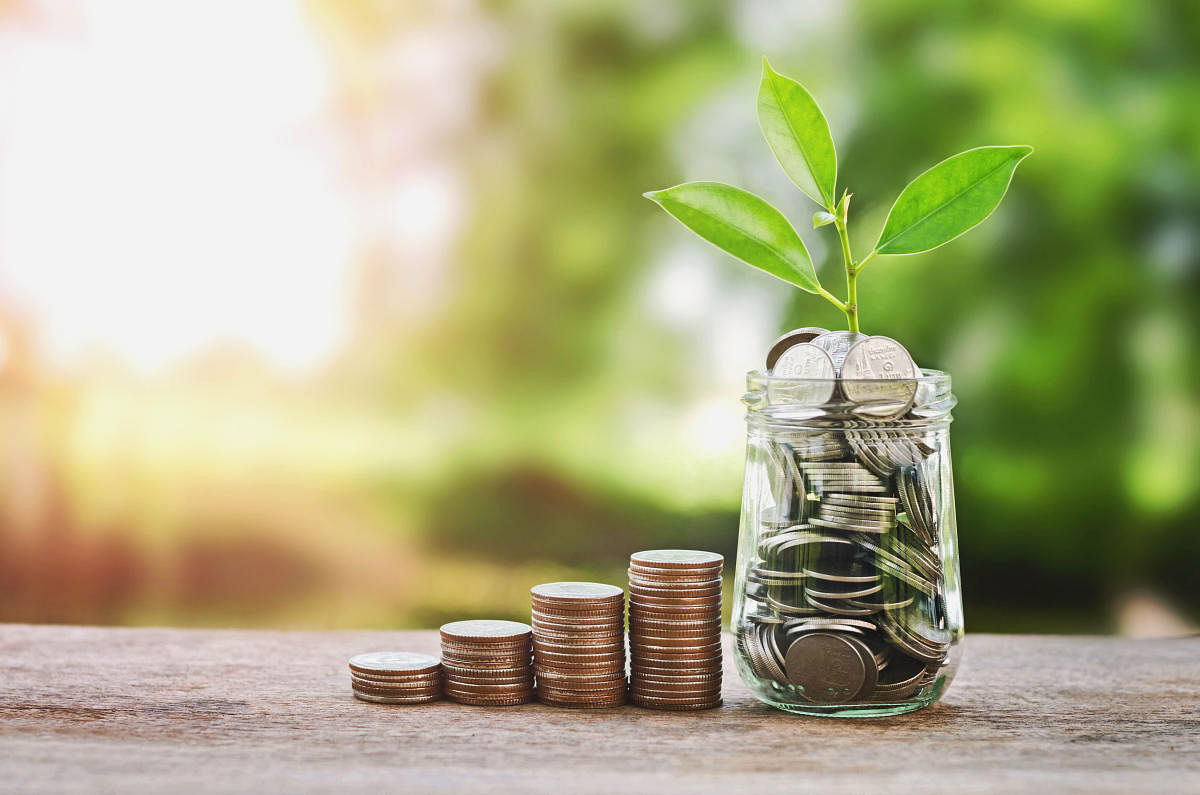 Plant growing on Coins glass jar and concept money savingEconomic growth