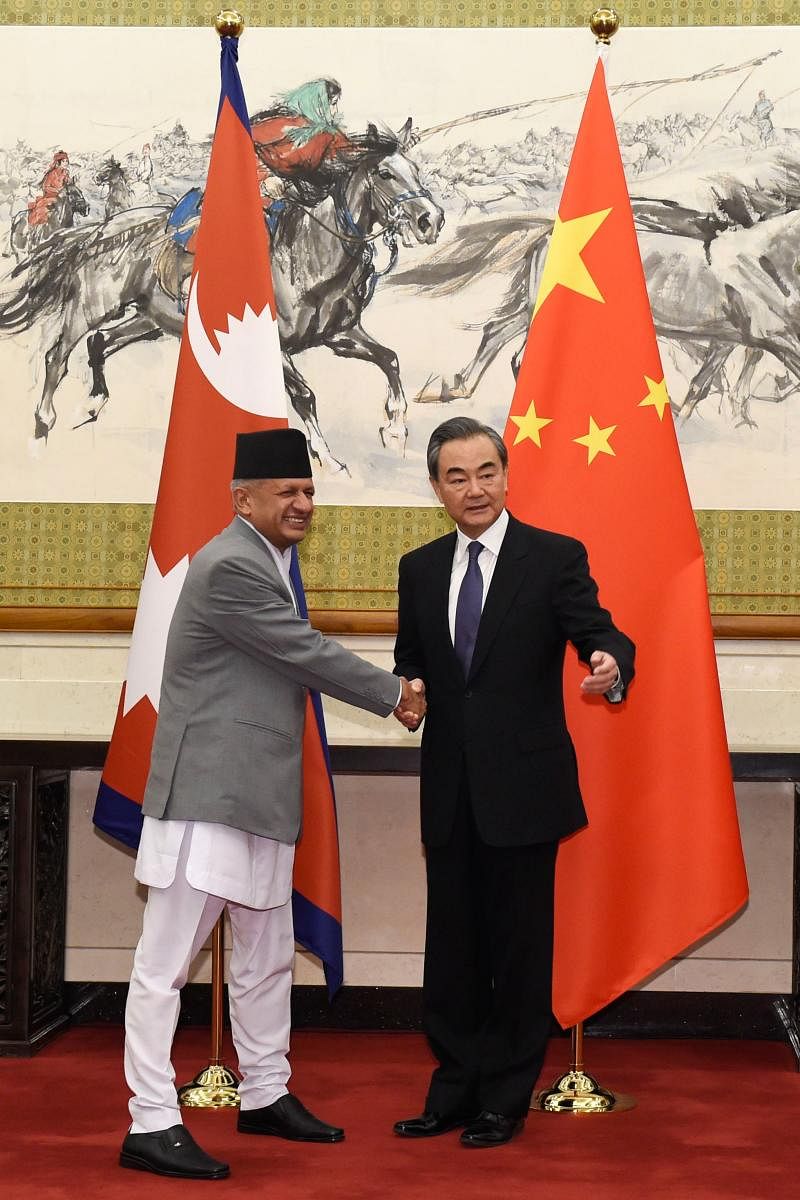 Nepal's Foreign Minister Pradeep Kumar Gyawali (L) shakes hands with his Chinese counterpart Wang Yi as they pose for the media before their meeting at the Diaoyutai State Guesthouse in Beijing on April 18, 2018. / AFP PHOTO / POOL / Parker Song