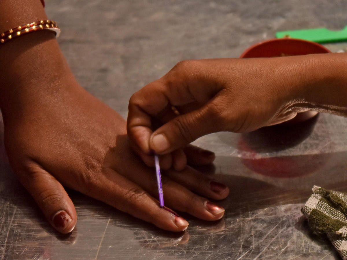 A polling officer applies an indelible ink mark on the finger of a voter at a polling station in Bengaluru outskirts on Tuesday. -Photo/ M S MANJUNATHIndelible Ink