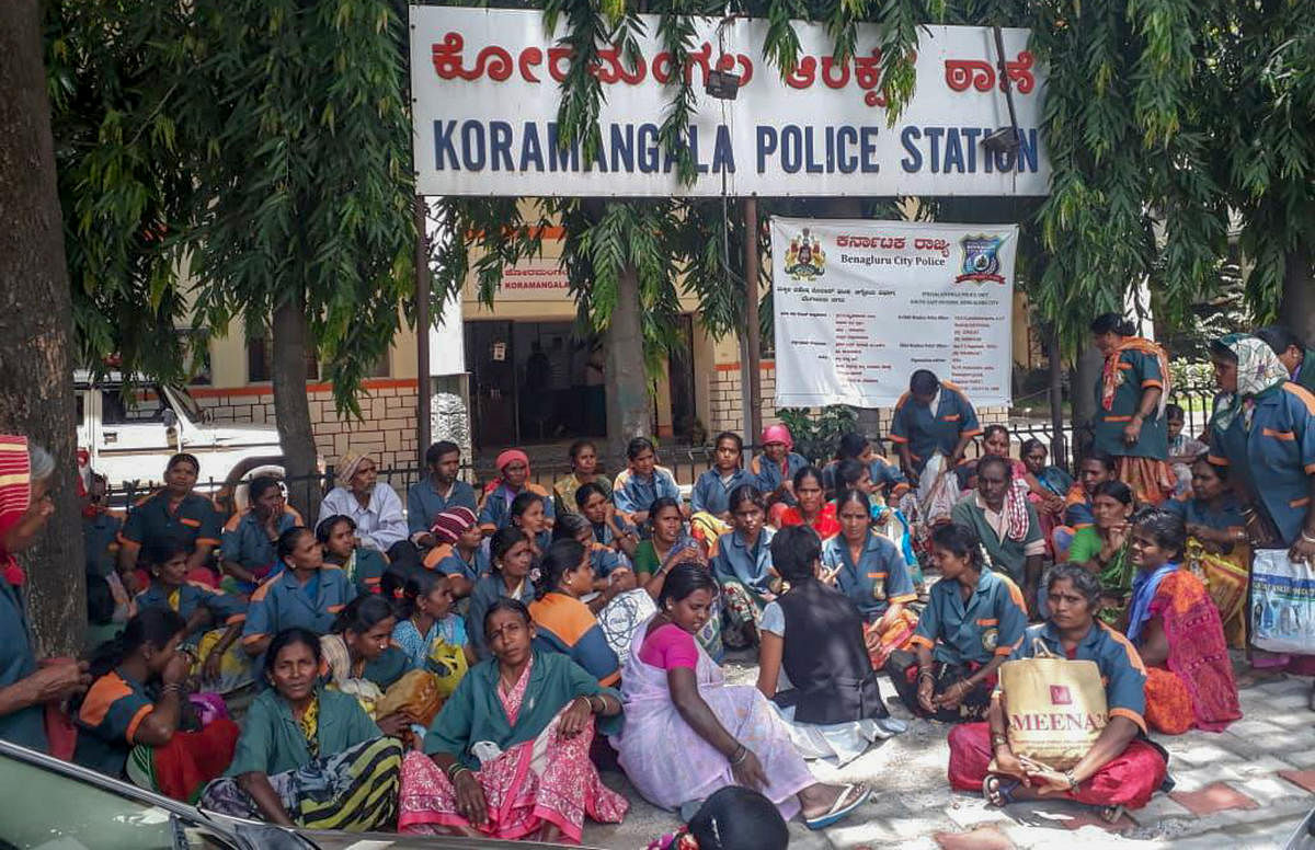 Pourakarmikas stage a protest in front of the Koramangala police station on Monday. 
