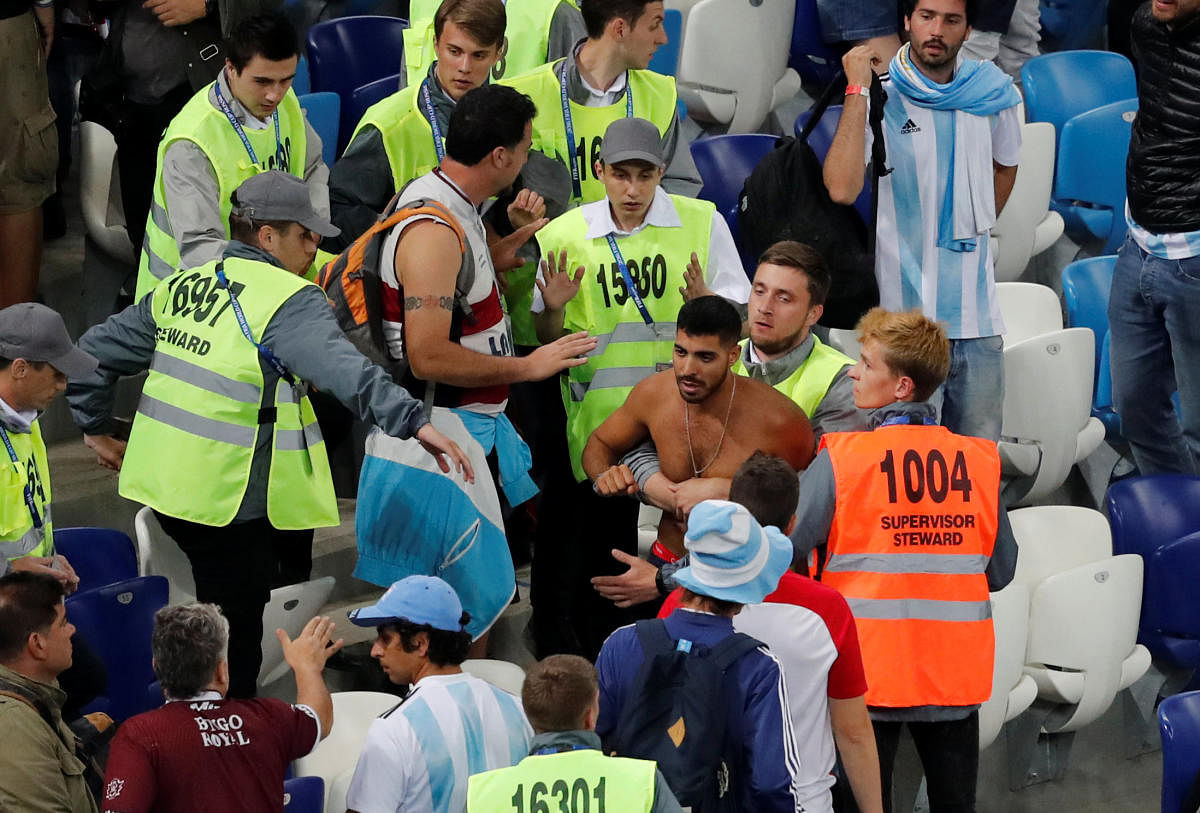 Stewards apprehend a fan after the match between Argentina and Croatia on Thursday. REUTERS