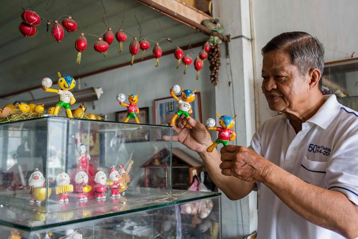 Retired Vietnamese English teacher Nguyen Thanh Tam displays various Football World Cup mascots including Fuleco (centre), the 2014 Brazil World Cup mascot, at his home in Ho Chi Minh City. AFP