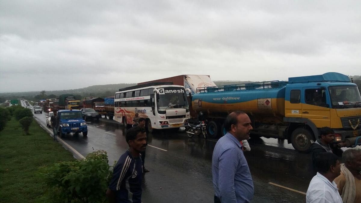 Vehicles line up on NH 4 near Hirebagewadi in Belagavi district after a KSRTC bus turned turtle in the middle of the road on Saturday morning. (DH Photo)