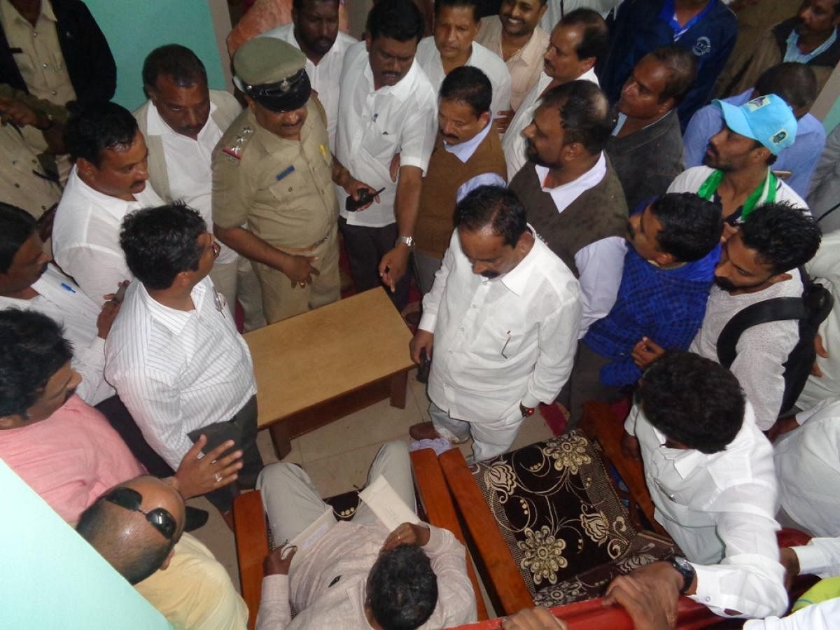 JD(S) workers raise slogans against JD(S) District President Sanket Poovaiah near Inspection Bungalow in Harangi near Kushalnagar on Thursday.