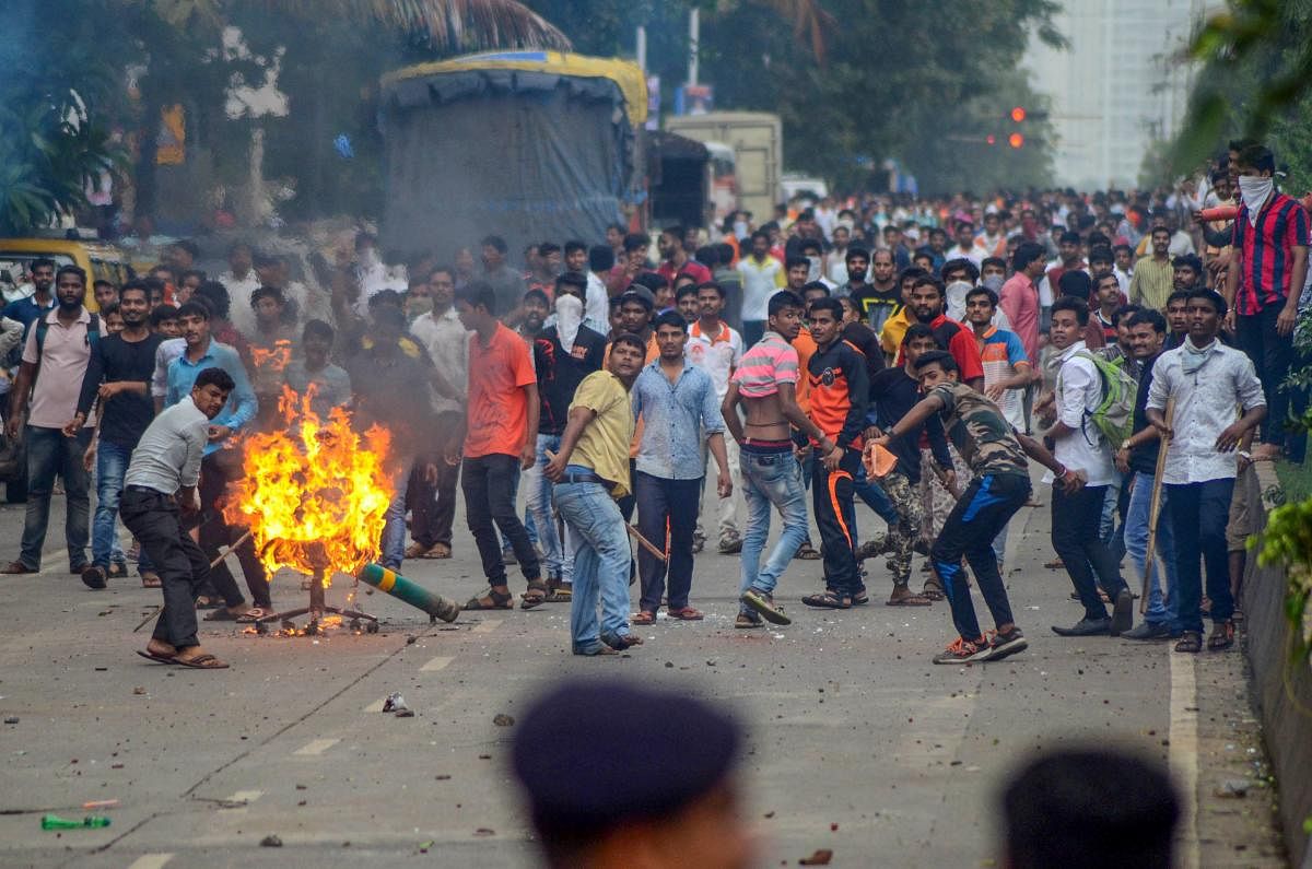 Navi Mumbai: Maratha Kranti Morcha protesters pelt stones at police personnel during their statewide bandh, called for reservations in jobs and education, in Navi Mumbai on Wednesday, July 25, 2018. (PTI Photo) (PTI7_25_2018_000230B)