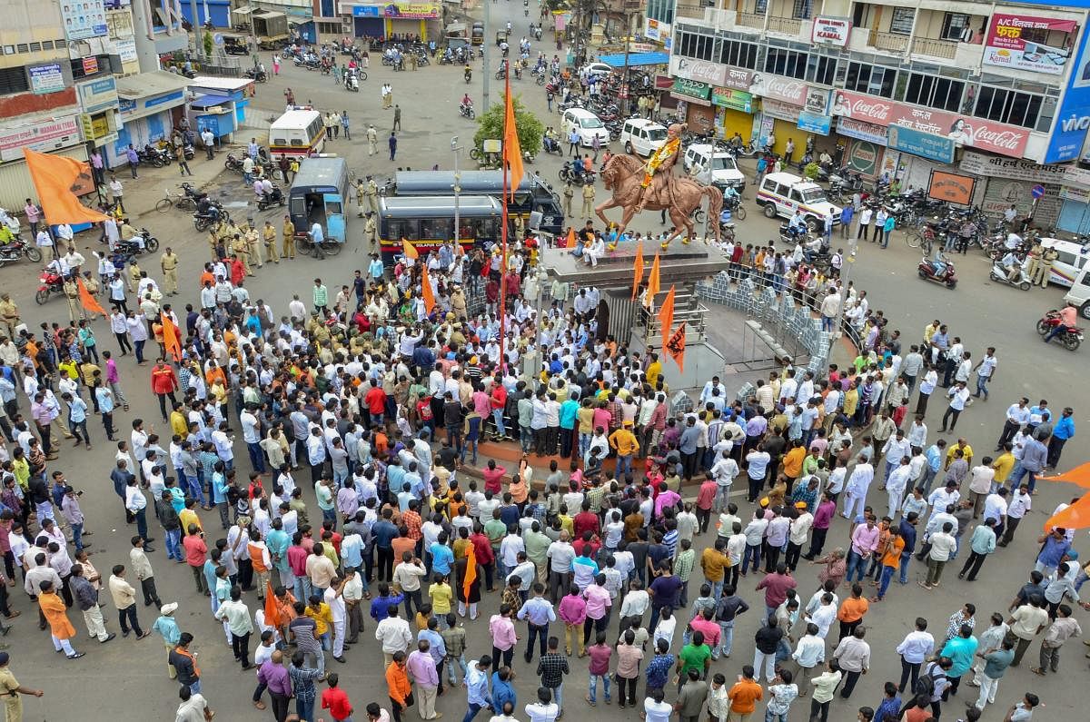 Maratha Kranti Morcha protesters block a road as police personnel keep a watch during their district bandh called for reservations in jobs and education, in Solapur, Maharashtra. PTI file photo