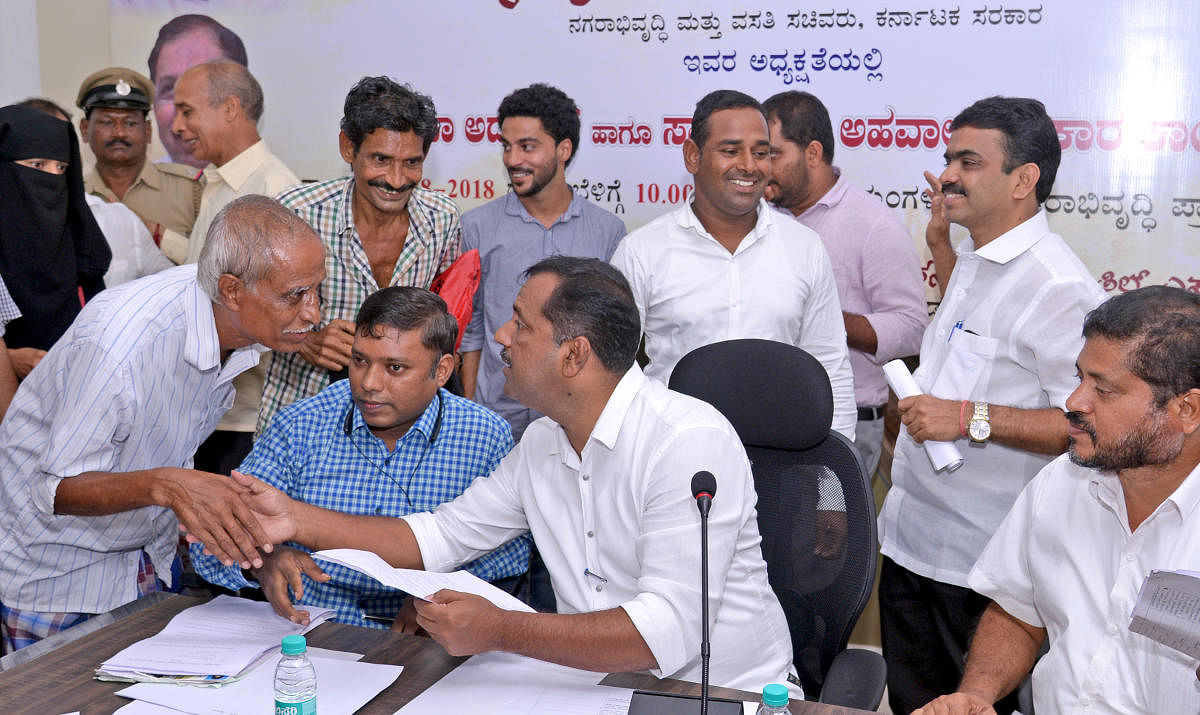 Minister for Urban Development and Housing U T Khader listens to grievances during a MUDA adalat in Mangaluru on Saturday.